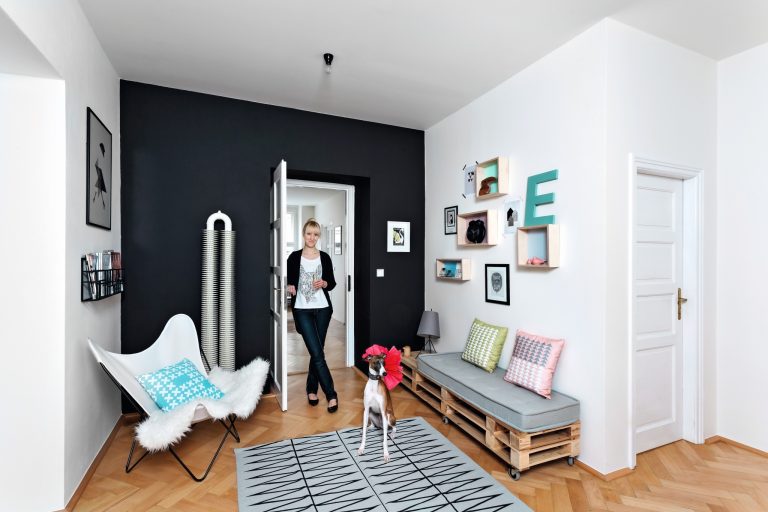 Nyní Designérka Andrea zútulnila velký minimalistický prostor pastelovým odstínem dekorací a různorodými rámečky. Příjemně působí černá výmalba, látky a nový koberec.