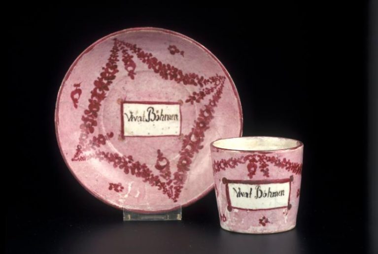 Kurátoři Jan Mergl a Lenka Pánková Merglová připravili výstavu, kterou otevírá nejstarší dochovaný porcelánový výrobek, koflík s nápisem „Vivat Böhmen“ z roku 1794
